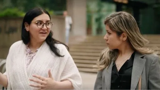 Two women have a conversation on a downtown Vancouver sidewalk