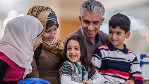 A smiling family comprised of three adults and two children