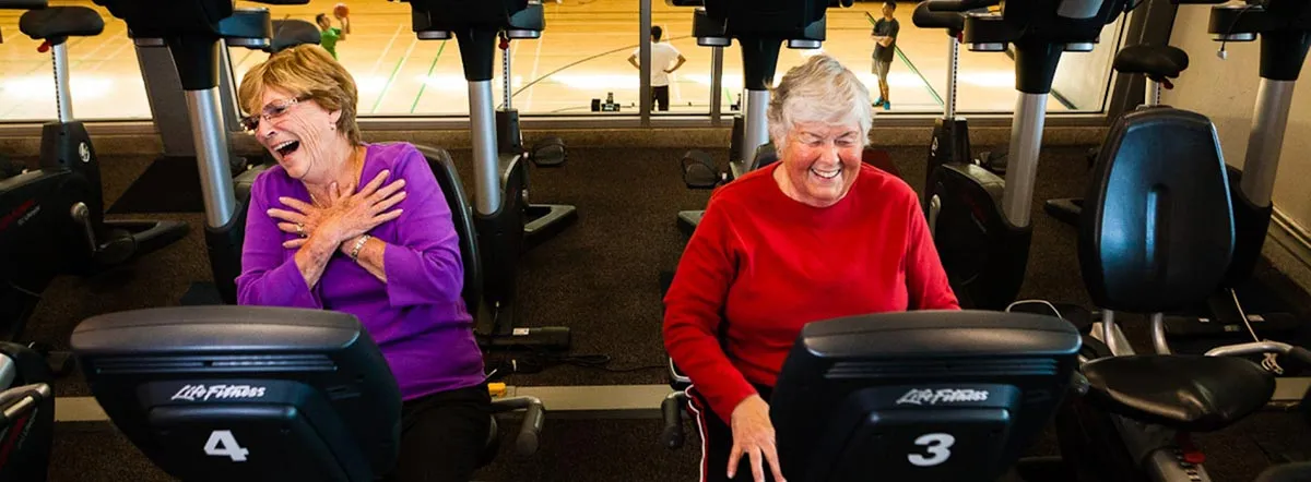 Two elderly women laughing while exercising at the Robert Lee YMCA in Vancouver