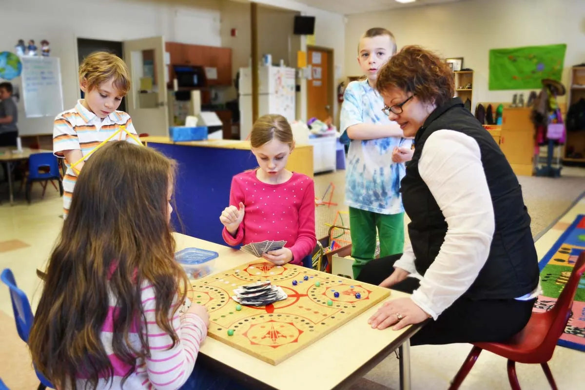 Child care provider sitting with children.