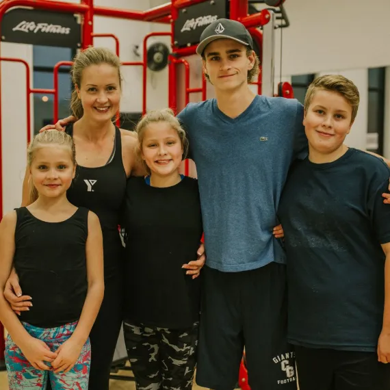 A mother with her four children at a YMCA fitness area
