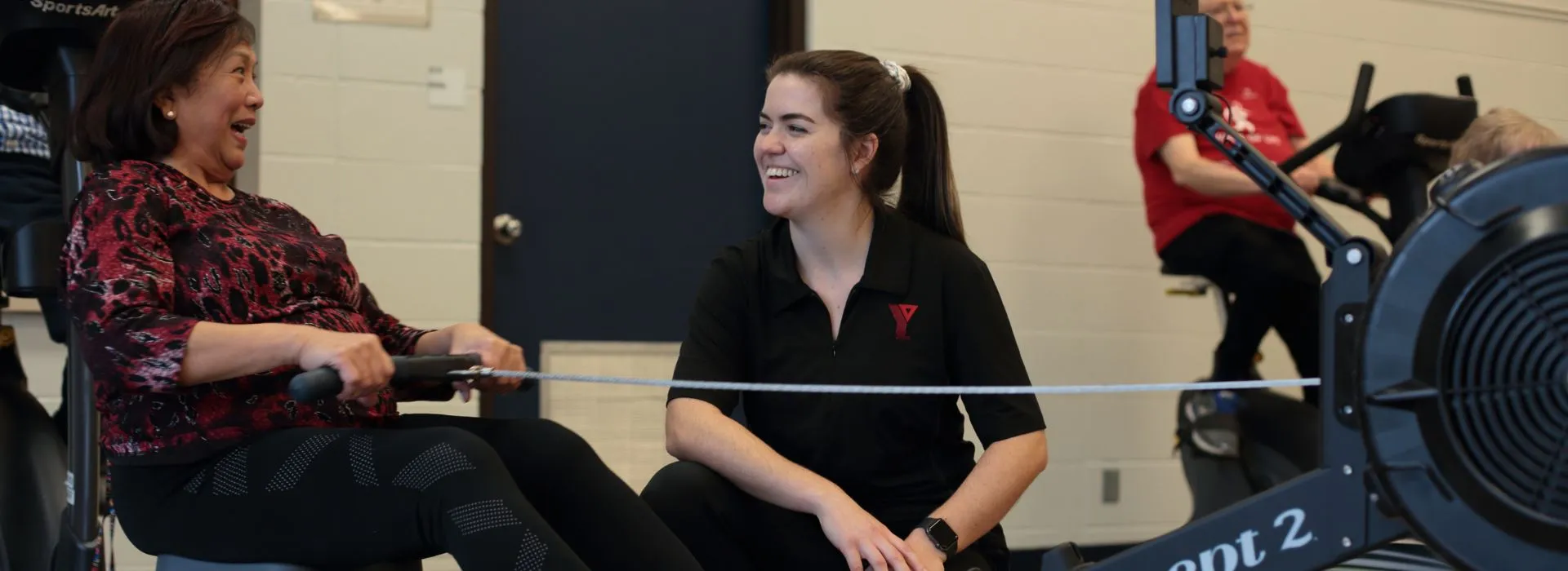 A YMCA Healthy Heart participant exercising and talk to a Program Facilitator