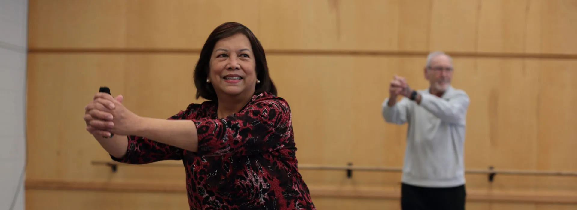 Two YMCA Healthy Heart participants in a guided group fitness activity